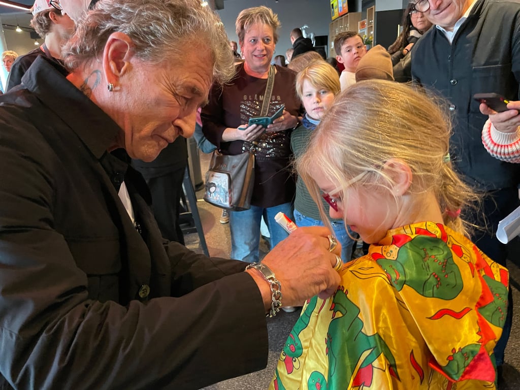 Promi-Alarm im Steintor: Rockstar Peter Maffay signiert für die sechsjährige Nele einen Umhang mit „Tabaluga“-Drachenmuster. Der Sänger stellte zur Premiere des Musicals „Anouk“ auch seine Peter-Maffay-Stiftung zugunsten benachteiligter Kinder vor.