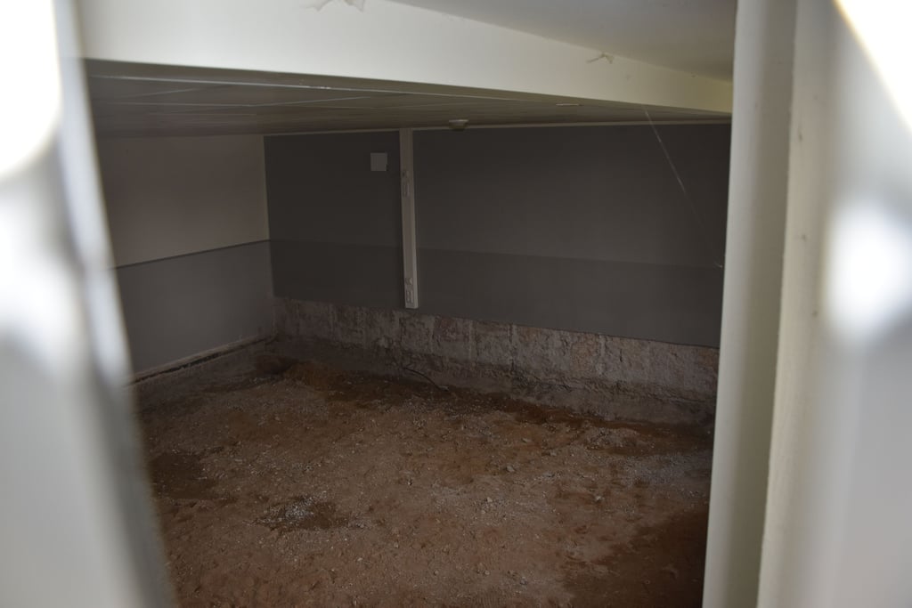 Blick durch ein geöffnetes Fenster in einen Unterrichtsraum im Keller der Sekundarschule Kalbe. Dorf fehlt der Estrich.