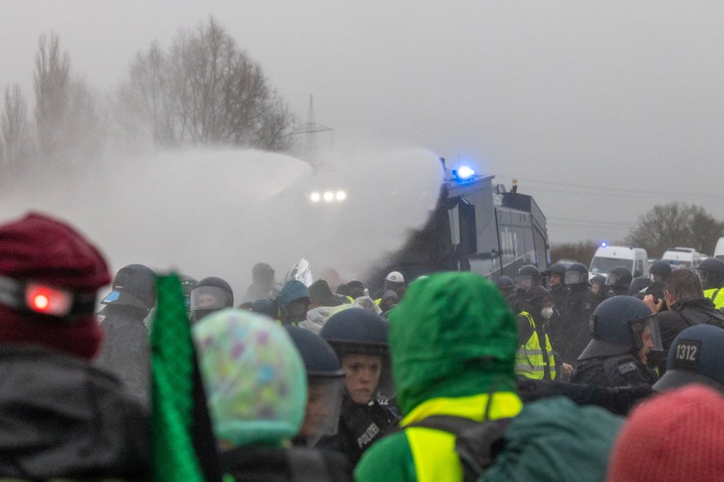 Die Polizei setzt Wasserwerfer gegen Demonstranten ein, die die B429 nahe der Lahnbrücke blockieren.