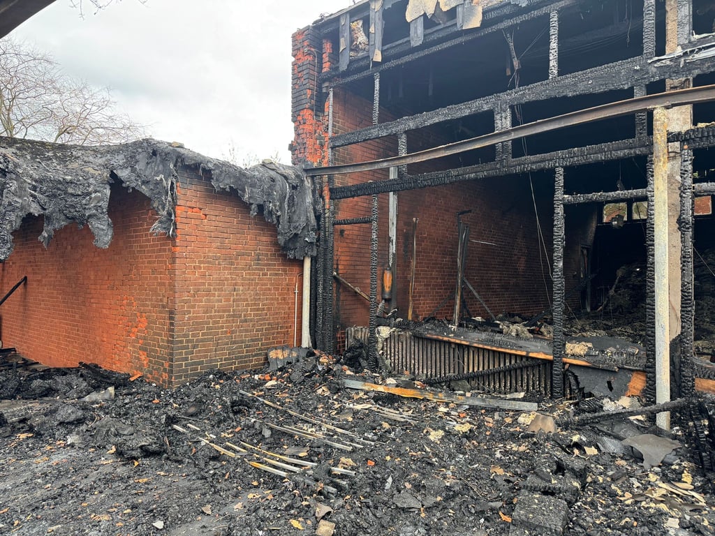 Vor der zerstörten Aula zeigt sich das Ausmaß des Brandes deutlich.
