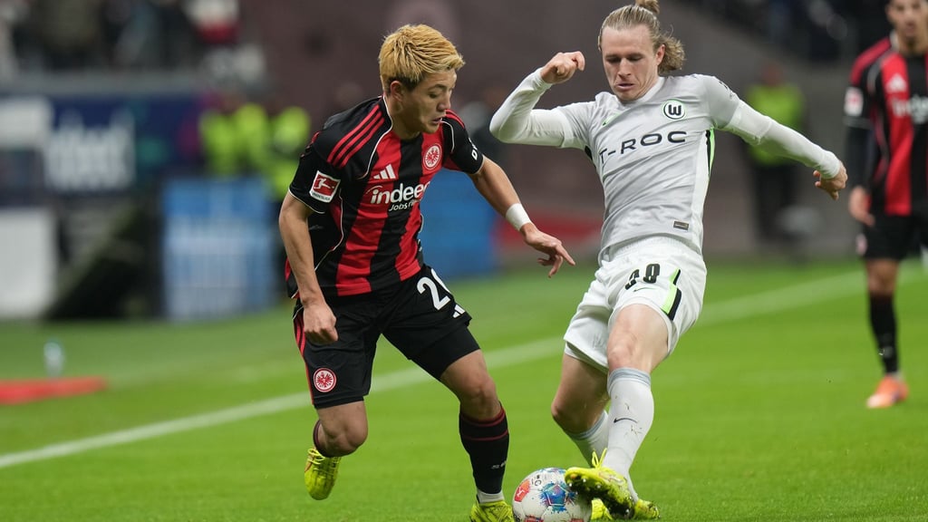 Lieferten sich eine umkämpfte Partie: Eintracht Frankfurt um Ritsu Doan (l) und der VfL Wolfsburg um Patrick Wimmer (r).