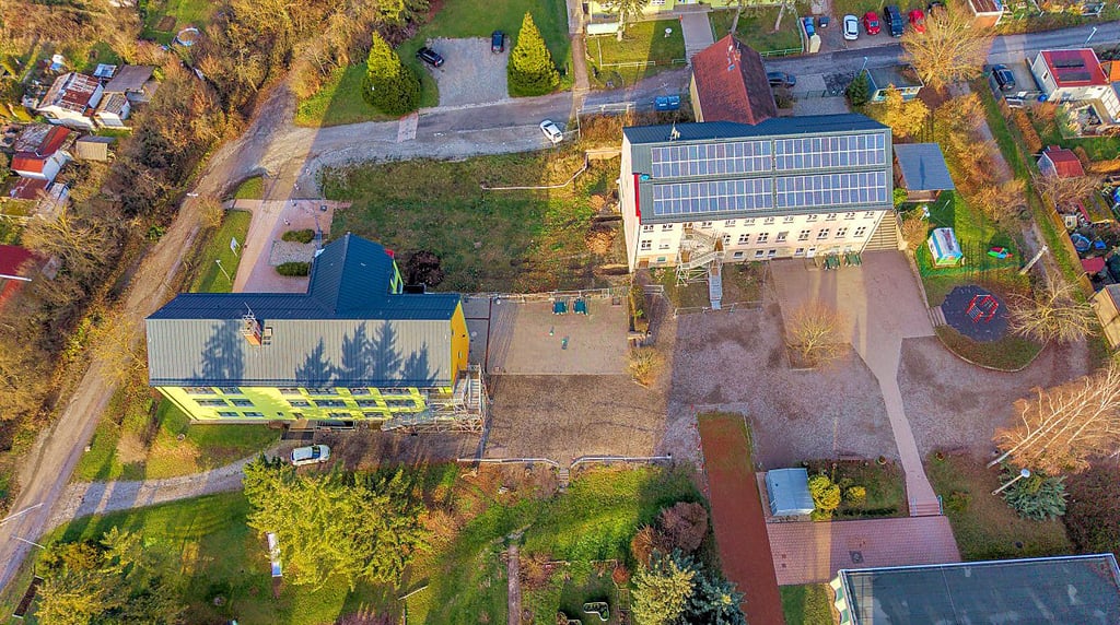 Der Schulstandort Eckartsberga am Mattstieg 13a aus der Vogelperspektive: Auf der Grünfläche zwischen „Alter Schule“ rechts und dem DDR-Bau links entsteht auf der  Rasenfläche das neue Schulgebäude.
