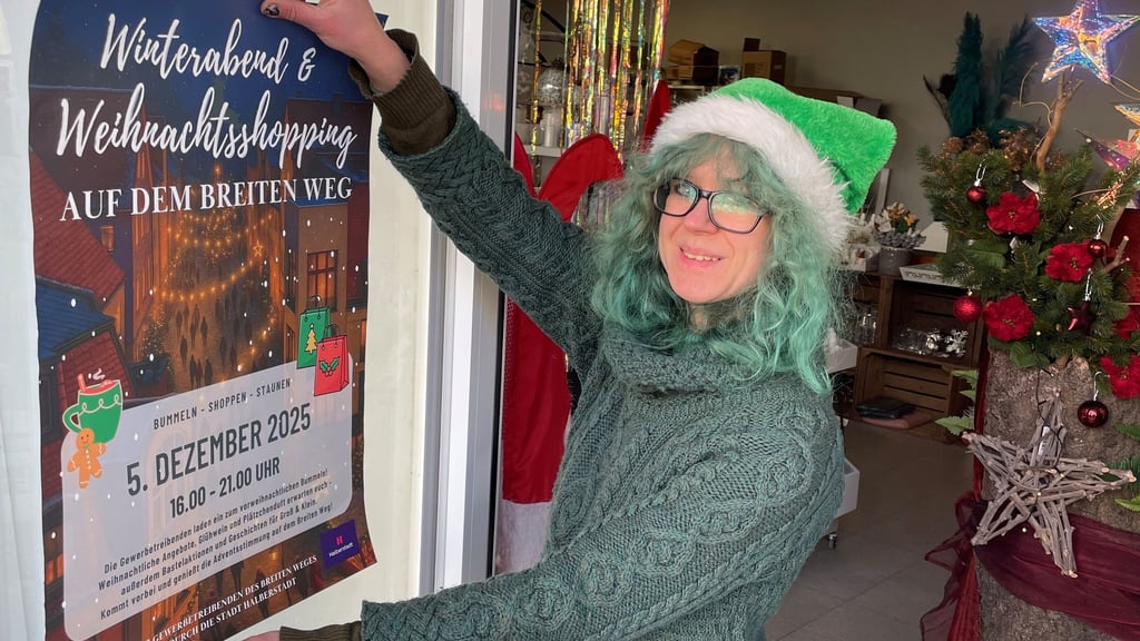 Floristin Sophie Schulz macht mit einem Plakat auf die Aktion  am Breiten Weg in Halberstadt aufmerksam.