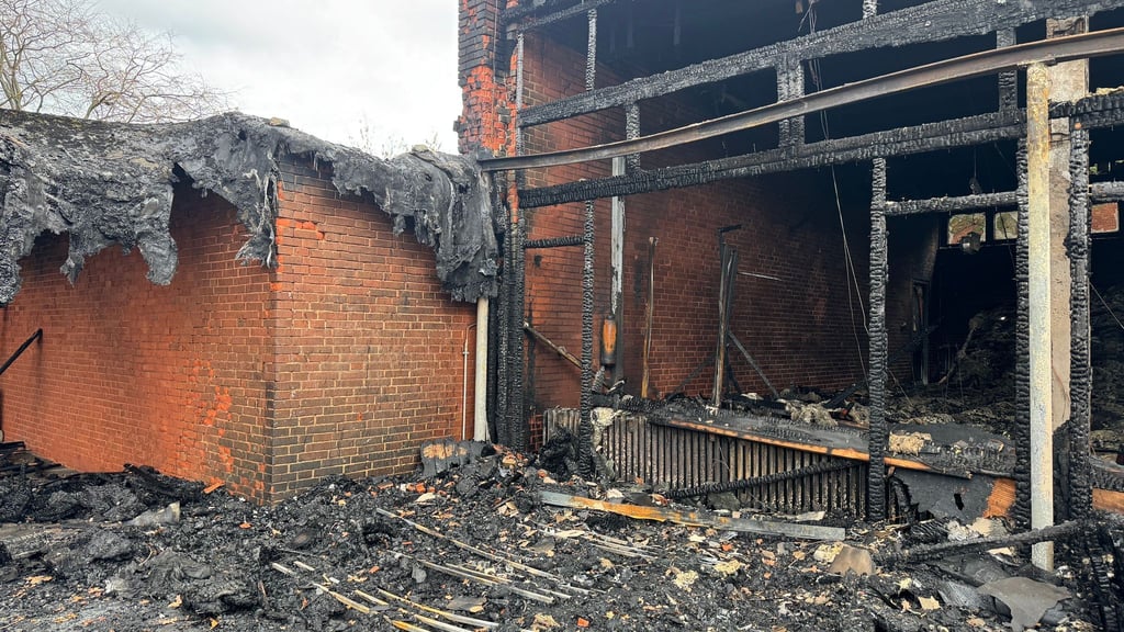 Vor der zerstörten Aula zeigt sich das Ausmaß des Brandes deutlich.
