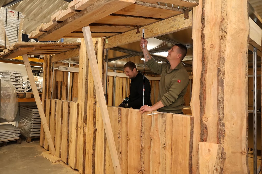 Diese flexible Verkaufsbude hat die Sangerhäuser Firma Ceteg für die ahaKultur GmbH konzipiert. Sie besteht aus vier Blöcken und hat 25 Quadratmeter Fläche. Das Holzhaus,  an dem Andy Lien und Felix Kosiol arbeiten, wird auf dem Weihnachtsmarkt und dann auch auf dem anschließenden Wintermarkt zu finden sein. 