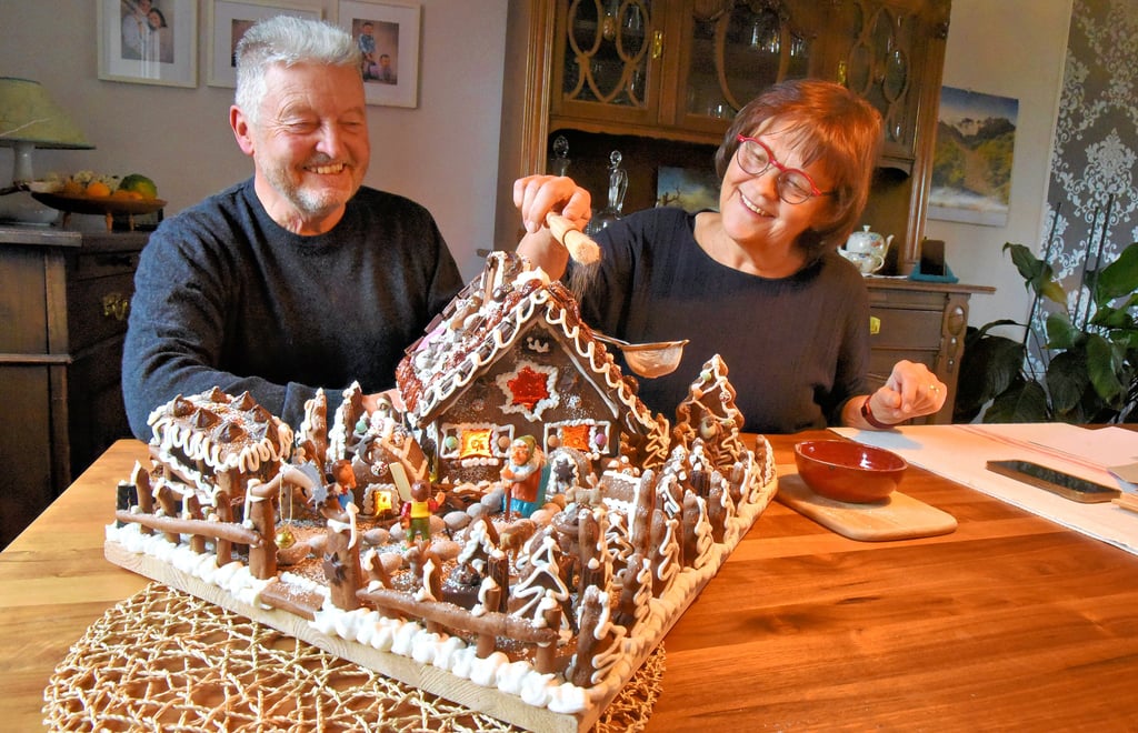 Letzter Akt, bevor es nach Augsburg auf die Reise geht: Margarete Mages krümelt Puderzucker über ihr Back-Kunstwerk. Ehemann Peter hält das Sieb. 