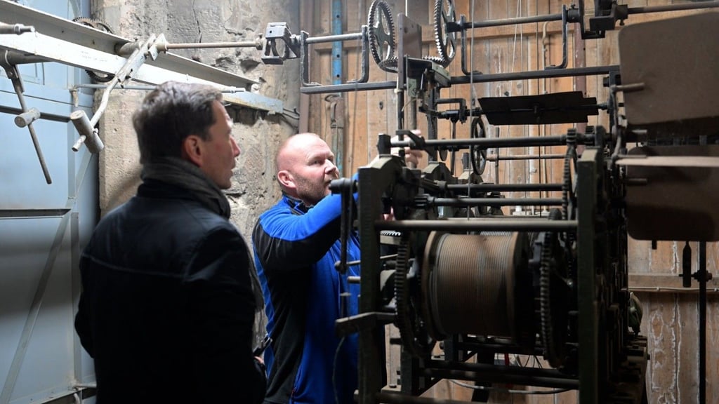 Oberbürgermeister Daniel Szarata (links) hat Jörg Winningstedt bei Arbeiten an der Martiniuhr über die Schulter geschaut.