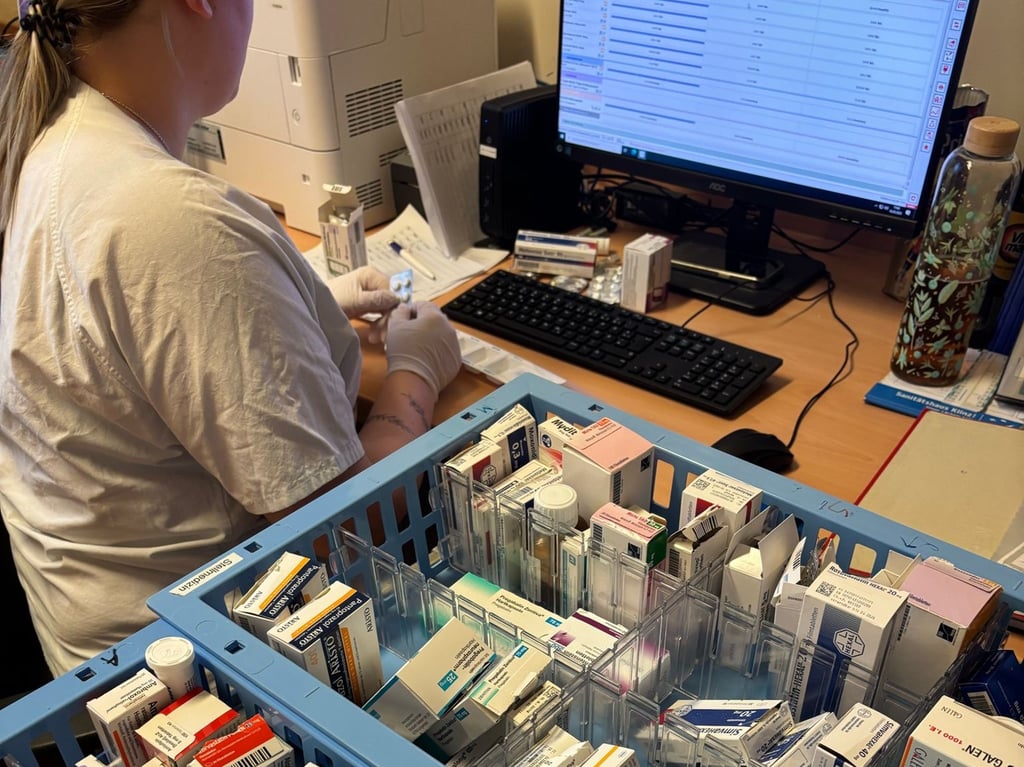 Eine Pflegekraft bereitet Tabletten für die Patienten vor. 