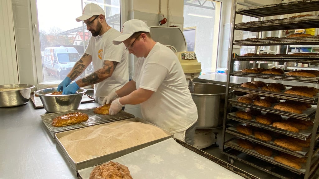 Daniel Blappert und Sabine Hilmer buttern und zuckern die Stollen ohne Rosinen, die bei der Halberstädter Bäcker & Konditoren GmbH hergestellt werden. Nach einem Rezept von Bäckermeister Peter Potratz.