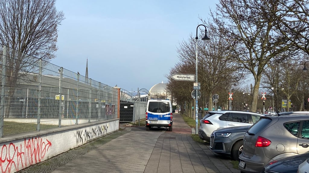 Ein Polizeifahrzeug sichert das Gerichtsgebäude in Magdeburg – und blockiert dabei teilweise den Geh- und Radweg.