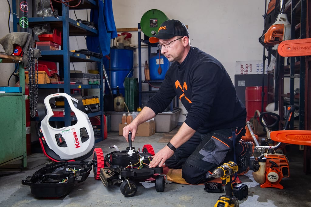 Manuel Meyer bei der Reparatur eines Mähroboters. An der Mechanik gehe kaum mehr etwas kaputt. Aber Pflege muss sein, sagt er.