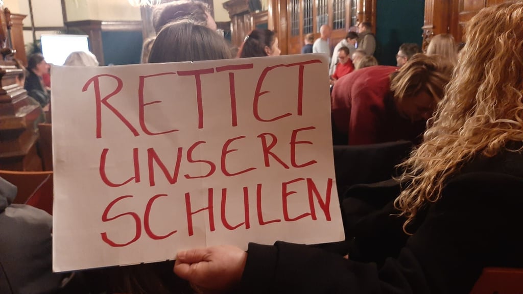 Im Bildungsausschuss am Dienstagabend wurden auch Protestschilder gegen die geplante Schulfusion gezeigt. 