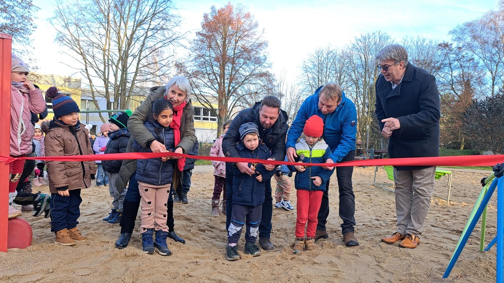 Kita-Leiterin Ines Franke, Thomas Richter (Geschäftsführer der Baufirma HTS) und Bürgermeister Dirk Fuhlert (v.li.) weihen gemeinsam mit den Kindern den neuen Spielplatz der Kita Weltentdecker in Hettstedt ein. 