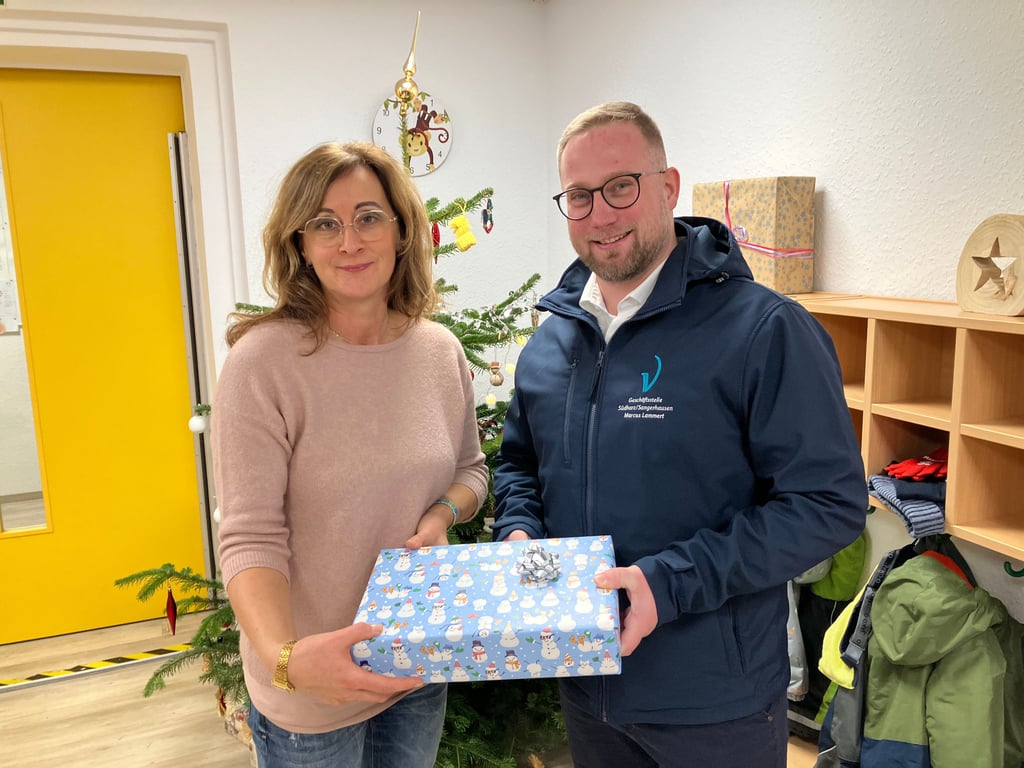 Nancy Stefan-Altmann, Leiterin der Kita „Pfiffikus“ in Bennungen,  nimmt das Geschenk von Marcus Lammert, Geschäftsstellenleiter der Pro-Ventus-Agentur Südharz/Sangerhausen,  entgegen. 