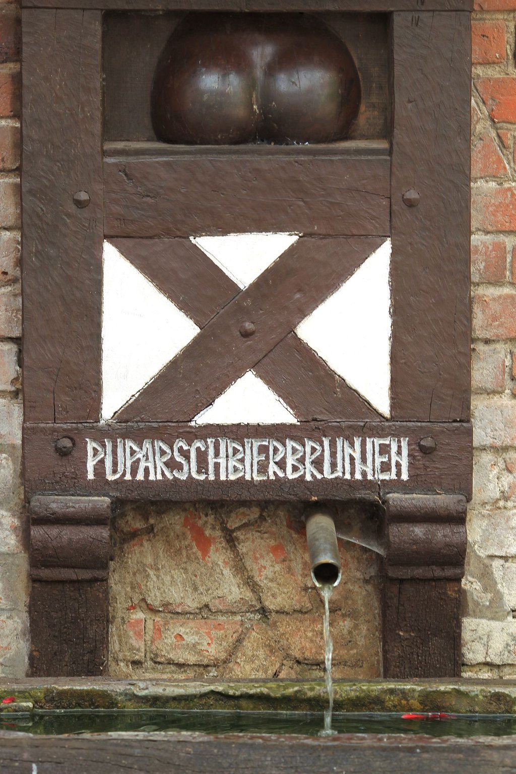 Der hölzerne Hintern befindet sich seit einigen Jahrzehnten an dem Brunnen. (Archivbild)