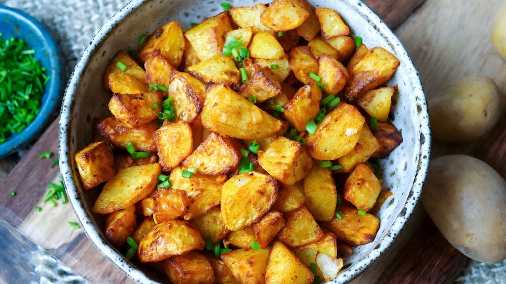 Nur kleine Mengen Fett bekommen Bratkartoffeln per Ölsprüher ab, werden mit Salz und Paprikapulver gewürzt und kommen in den Airfryer: Nach 25 Minuten sind die Kartoffelstücke richtig schön knusprig.