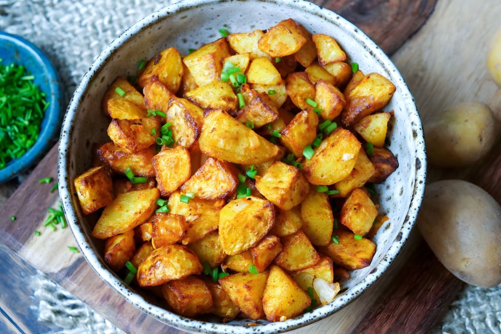 Nur kleine Mengen Fett bekommen Bratkartoffeln per Ölsprüher ab, werden mit Salz und Paprikapulver gewürzt und kommen in den Airfryer: Nach 25 Minuten sind die Kartoffelstücke richtig schön knusprig.