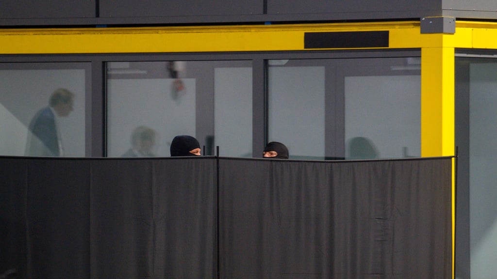 Justizbeamte bauen im Gerichtssaal des temporären Gerichtsgebäudes vom Landgericht Magdeburg probeweise Sichtschutzwände vor den Glaskasten, in dem später der Angeklagte sitzen wird. Die Sichtschutzwände sollen verhindern, dass eine Zeugin den Angeklagten sehen muss.