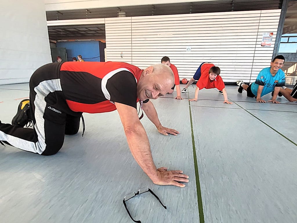 Götz Hupe macht auch mit 70 allen noch was vor. Hier zeigt er den Kids, wie ein verkürzter Liegestütz funktioniert. Er hat aber auch noch den richtigen drauf.