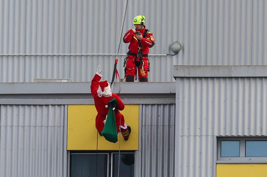 Ein Feuerwehr-Nikolaus seilt sich am Städtischen Klinikum Magdeburg ab, um dann Patienten in der Kinderklinik einige Überraschungen zu schenken. Eine Tradition der Berufsfeuerwehr Magdeburg. 