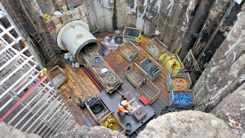 Blick in die Startgrube: Hier beginnt der 600 Meter lange Tunnel. Arbeiter holen mit einem kleinen Transporter aktuell die Bohrtechnik aus der Röhre. 