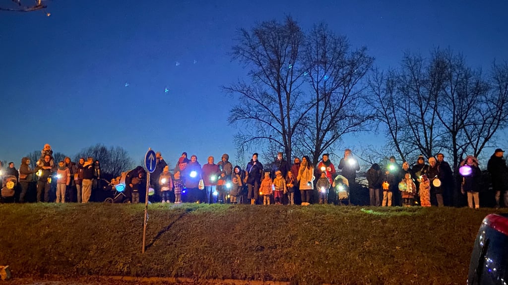 Ein Lichtband gegen die Dunkelheit: Eltern, Kinder und Besucher des ASZ Cracau bilden am Deich an der Büchnerstraße eine stimmungsvolle Lichterkette.