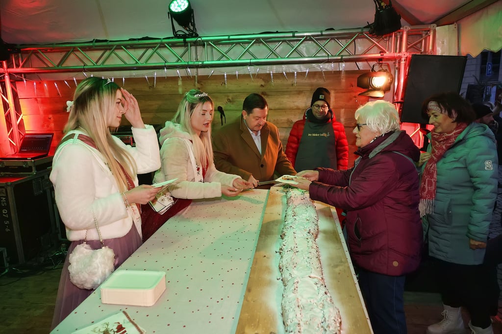 Christel Lemaire (2.v.r.) holte sich zur Eröffnung des Weihnachtsmarkts in Sangerhausen ein Stück des leckeren Riesenstollens.