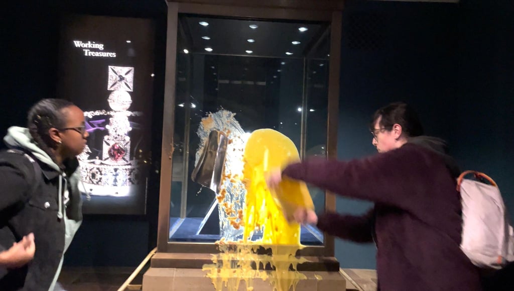 Aktivisten beschmieren die Vitrine, in der die Krone ist.