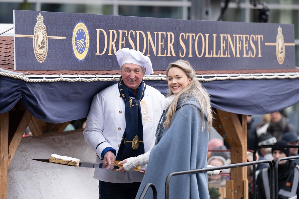 Bäckermeister Reiner Israel und Stollenmädchen Johanna Worm präsentieren zum Dresdner Stollenfest ein Stück vom Riesenstollen.