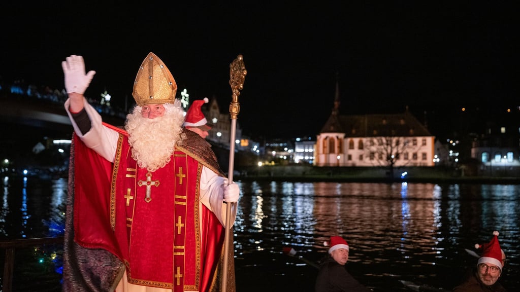 Von zahlreichen Fackelschwimmern begleitet ist der Nikolaus in Bernkastel-Kues in einem Ruderboot über die Mosel gekommen.