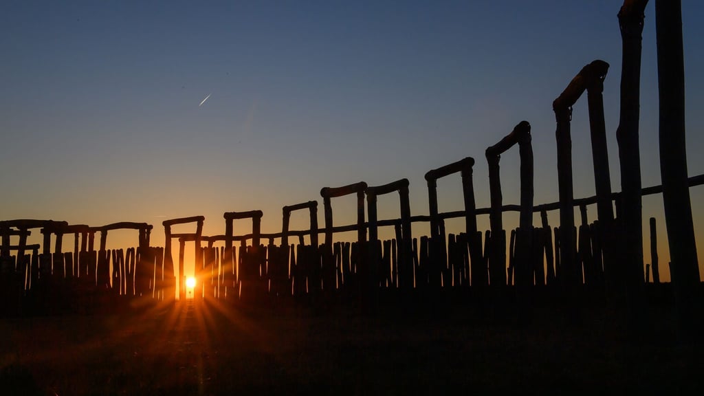 Die Sonne geht hinter den Stelen und Toren vom Ringheiligtum Pömmelte unter. (Archivbild)