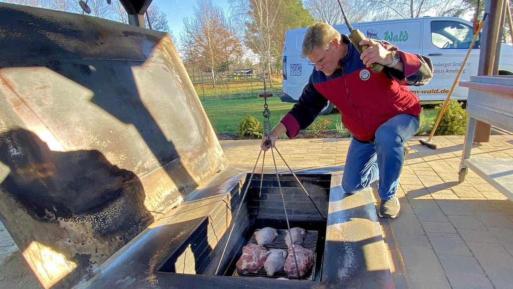 Der Annaburger Gerald Lexius lässt eine „Fuhre“ mit vorbereiteten Enten in den Erdofen hinabfahren. Nach rund fünf Stunden sind sie gar.