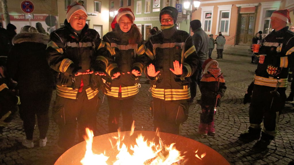 Janine Wende (von links), Anna Dockal und Andrea Fröhlke wärmen sich hier an dem großen Feuer in der Feuerschale auf dem Marktplatz die Hände. 