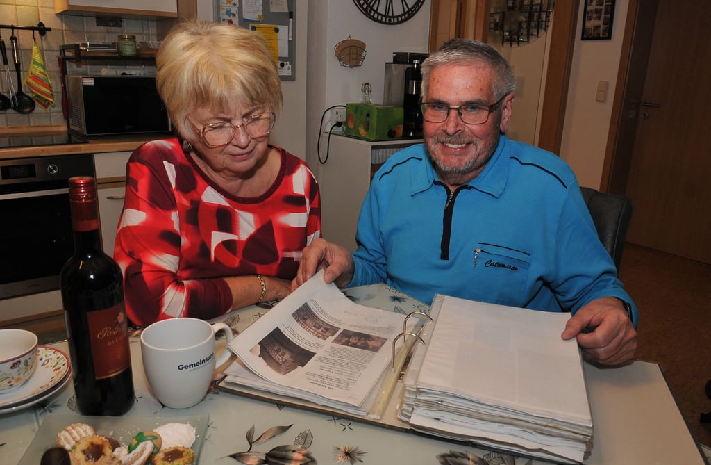 Karin Muchau und Günther Herforth-Unger blättern in der Familienchronik. 