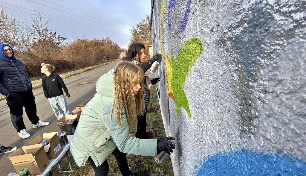 Emily (vorn) gestaltet die Wand mit sicherer Hand, während Mia neben ihr an ersten weihnachtlichen Details arbeitet.