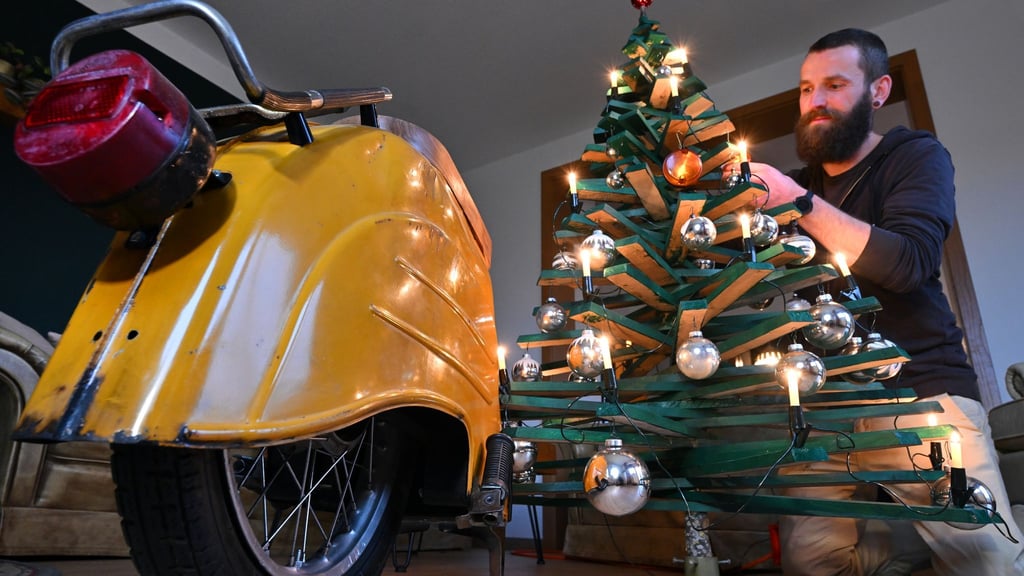 Jan Hofmann schmückt einen Weihnachtsbaum auch mit Weihnachtsbaumkugeln aus Simson-Blinkern.