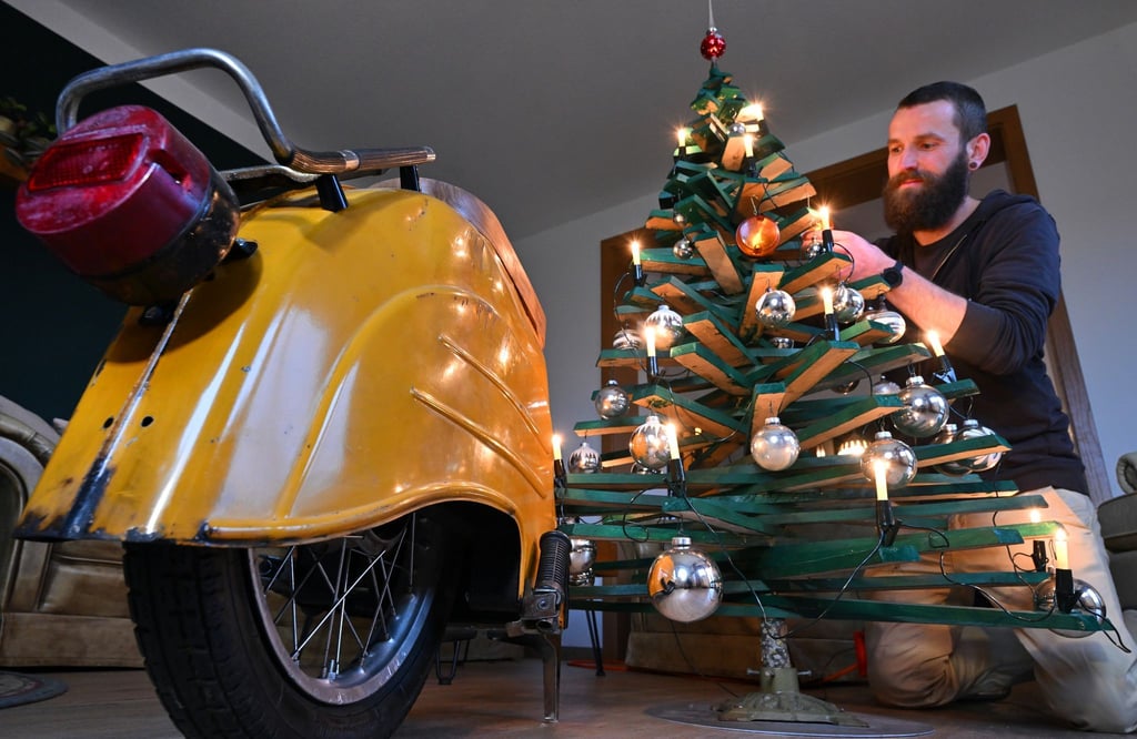 Jan Hofmann schmückt einen Weihnachtsbaum auch mit Weihnachtsbaumkugeln aus Simson-Blinkern.