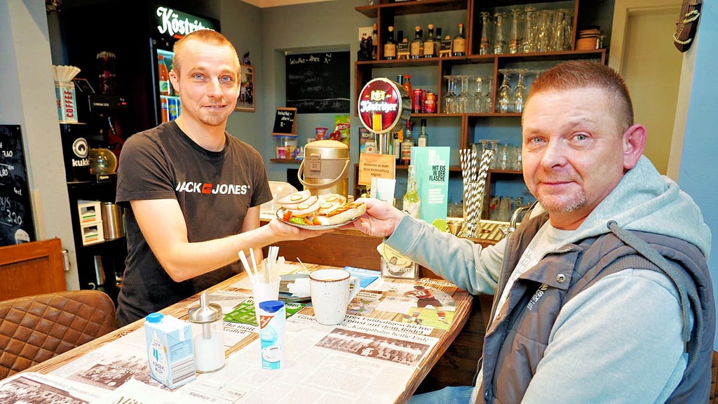 Christian „Itze“ Lehwald (l.) serviert einem Gast Frühstück. Durch den temporären Wechsel ins "Roccos" kann er erstmals im T-Shirt arbeiten. Im Imbiss ab der B180 geht das im Winter nicht.&nbsp;&nbsp;