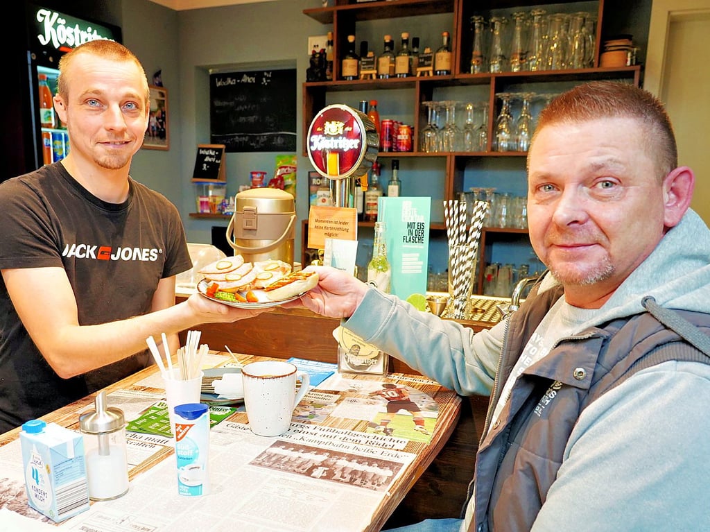 Christian „Itze“ Lehwald (l.) serviert einem Gast Frühstück. 
