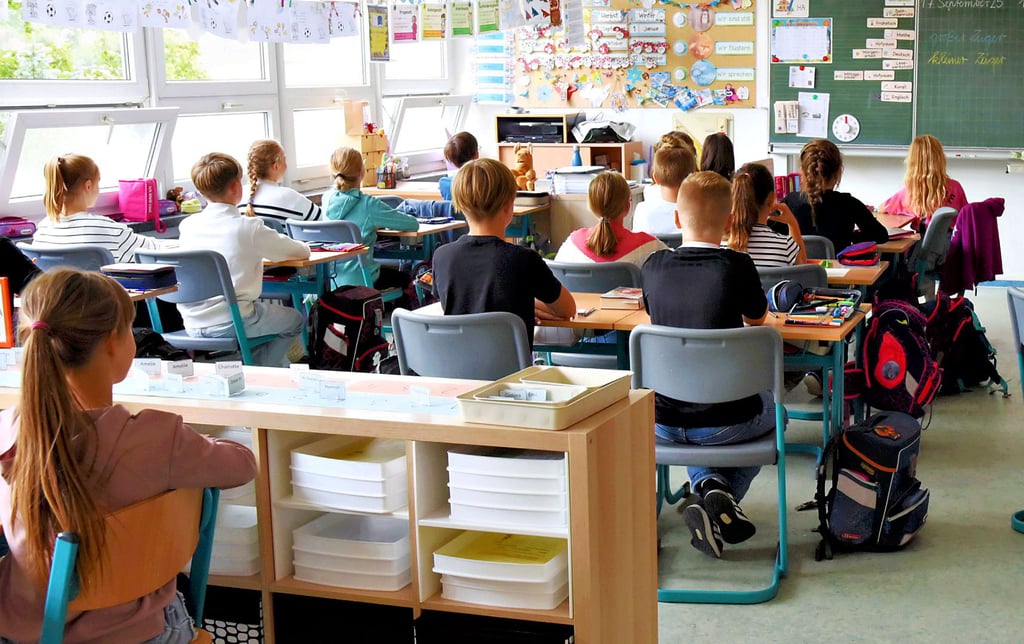 Kinder sitzen in einem Raum der Ratke-Grundschule in der Hugo-Junkers-Straße.  