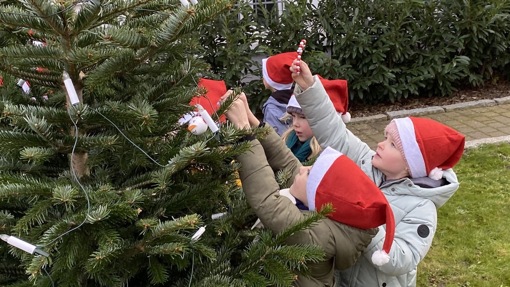 Kinder der Klasse 1a der Ludwig-Uhland-Grundschule schmückten einen Tannenbaum bei der GWG.