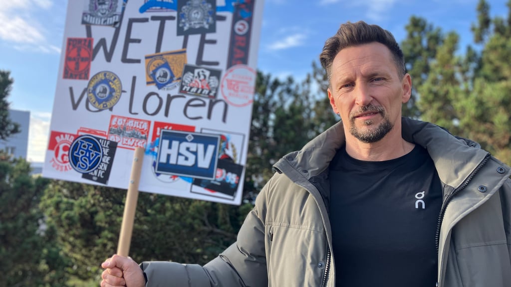 Merh als 10.000 Wetten hat er verloren: Mit diesem Schild und im Trikot des Gegners stellt sich Thomas Melchior vor Fußballstadien