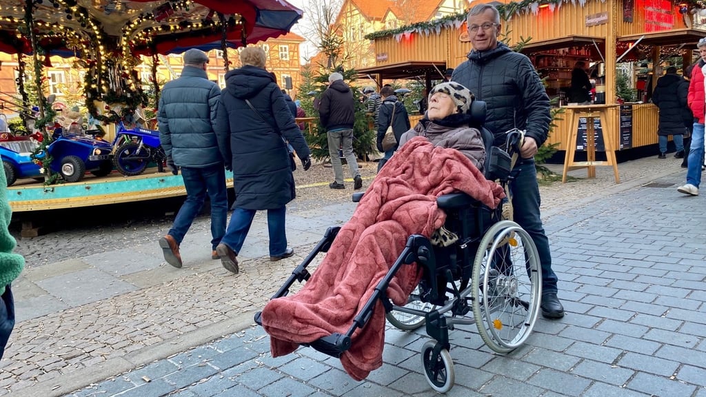 Roland Jahn schiebt den Rollstuhl seiner Mutter Elfriede über den Wernigeröder Weihnachtsmarkt.
