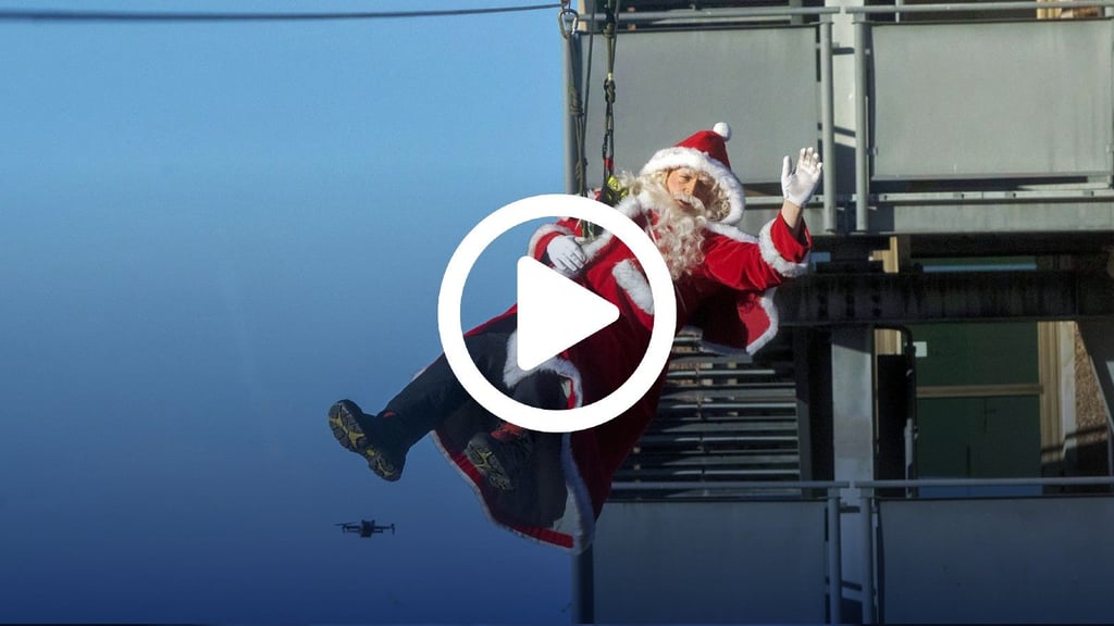 Der Nikolaus seilt sich zu den wartenden Kindern vor dem Städtischen Klinikum ab.
