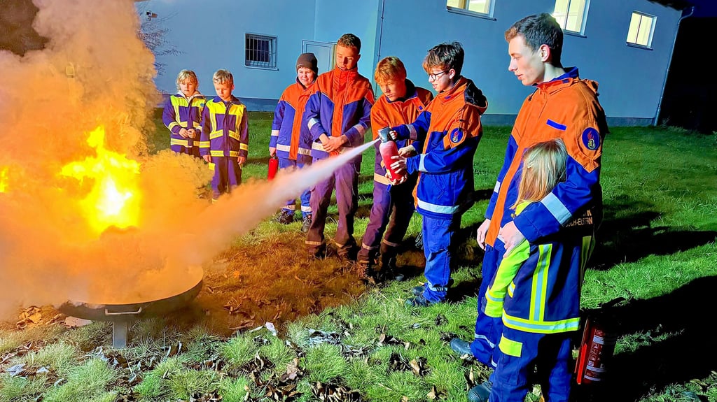 Gleich ist das Feuer aus.   Kinder und Jugendliche  der Feuerwehr Elster     löschen einen  brennenden Adventskranz.