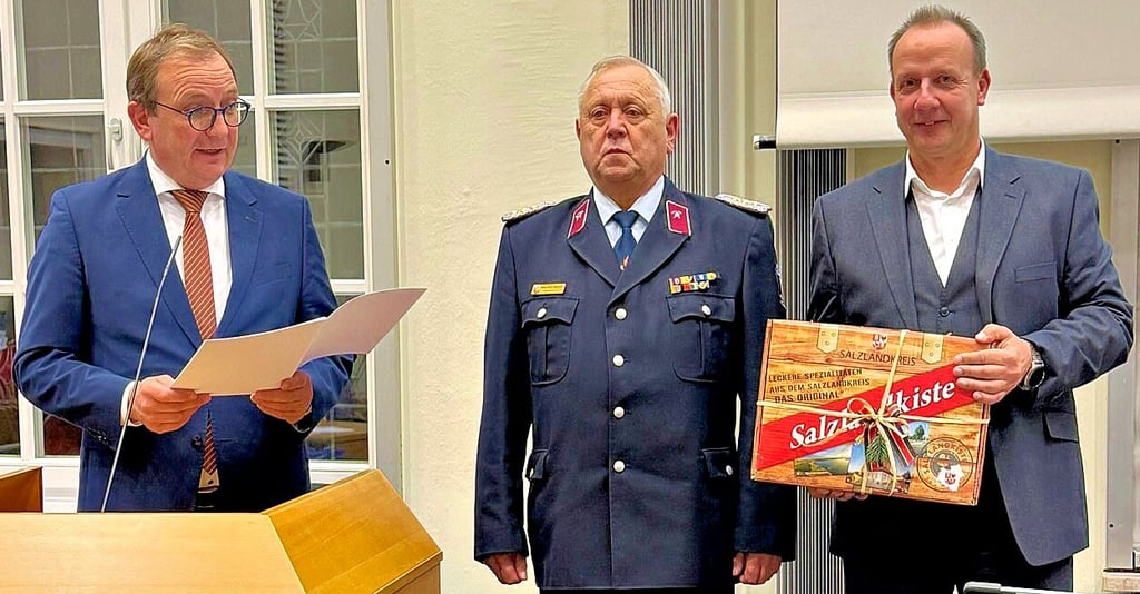 Landrat Markus Bauer (links) verlieh Hans-Ulrich Robitzsch (Mitte) auf Kreistagsbeschluss den Titel Ehrenkreisbrandmeister. Kreistagspräsident Thomas Gruschka gratulierte mit einer Salzlandkiste. 