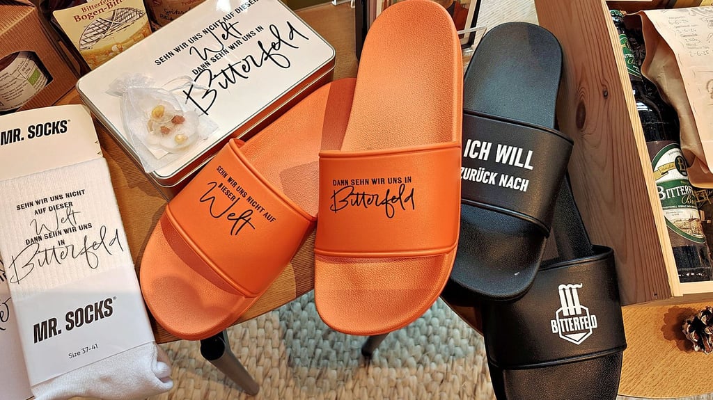 Die bunten Badelatschen mit Bitterfeld-Sprüchen  sind ein Hingucker, ebenso wie die weißen Socken.