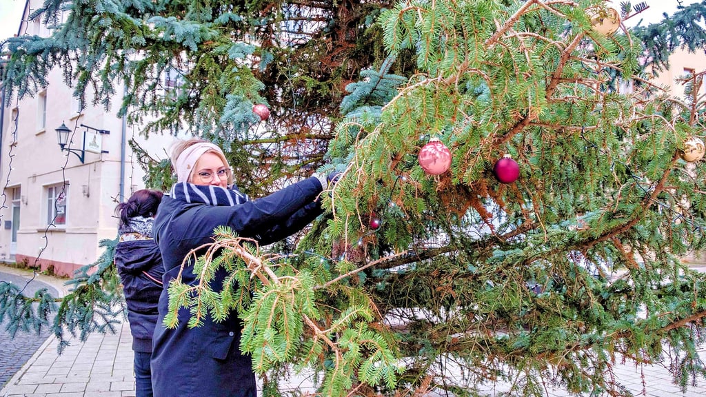Nicole Täsch beim Schmücken des großen Weihnachtsbaums auf dem Marktplatz in Gräfenhainichen 