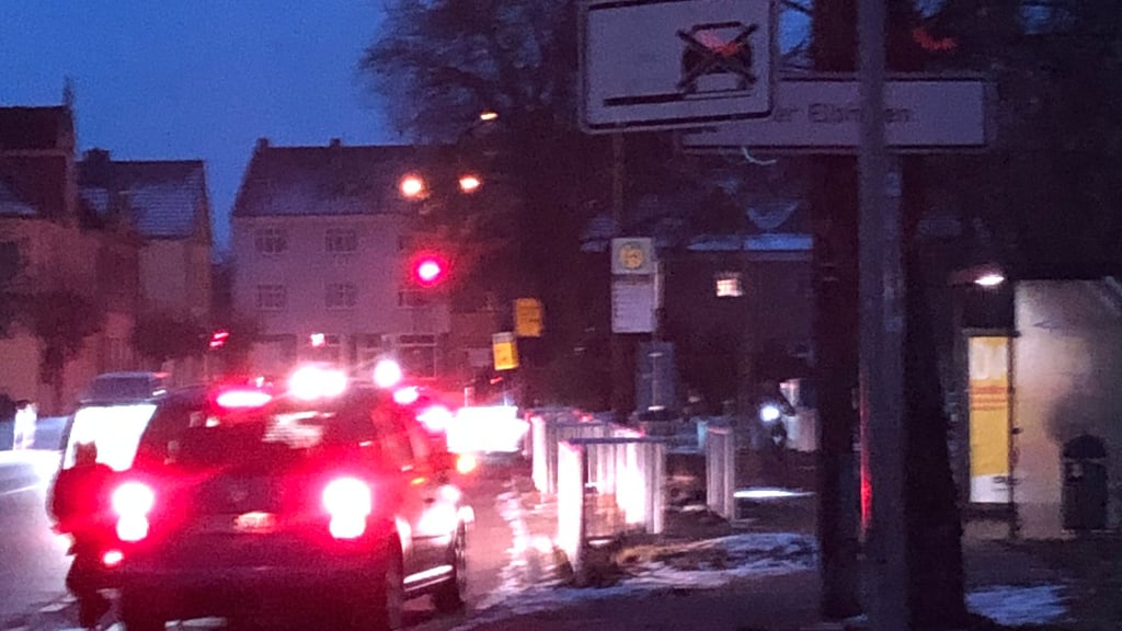 In den dunklen Morgenstunden hält ein Fahrzeug im Bereich des Haltverbots, während ein Kind zur Fahrbahnseite aussteigt. 