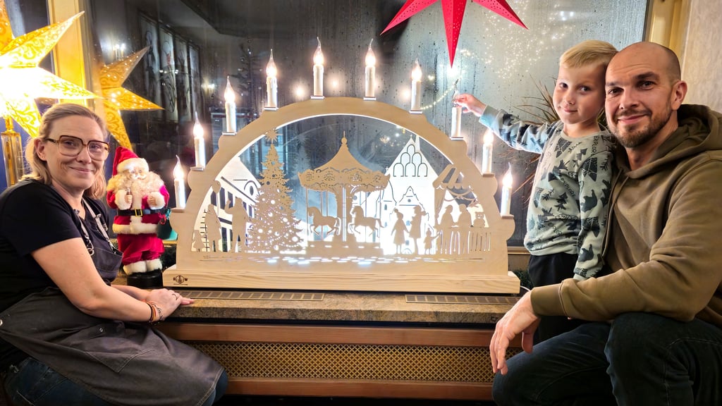 Auf dem Zerbster Weihnachtsmarkt soll dieser Schwibbogen mit dem Motiv der Bartholomäikirche versteigert werden, der derzeit noch im Schaufenster der Schlosskonditorei zu bewundern ist. Geschaffen hat ihn Robert Willno, hier mit Sohn Mattes, der seinem Vater beim Werkeln gern zu Hand geht.